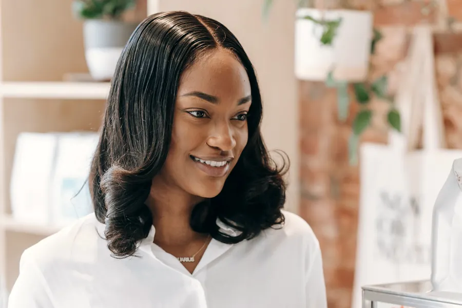 A smiling shop owner in a white shirt in her shop